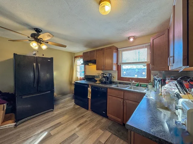 a kitchen with stainless steel appliances granite countertop a refrigerator a stove top oven a sink dishwasher and wooden cabinets