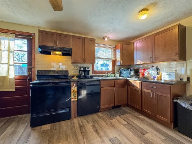 a kitchen with granite countertop wooden cabinets and a sink