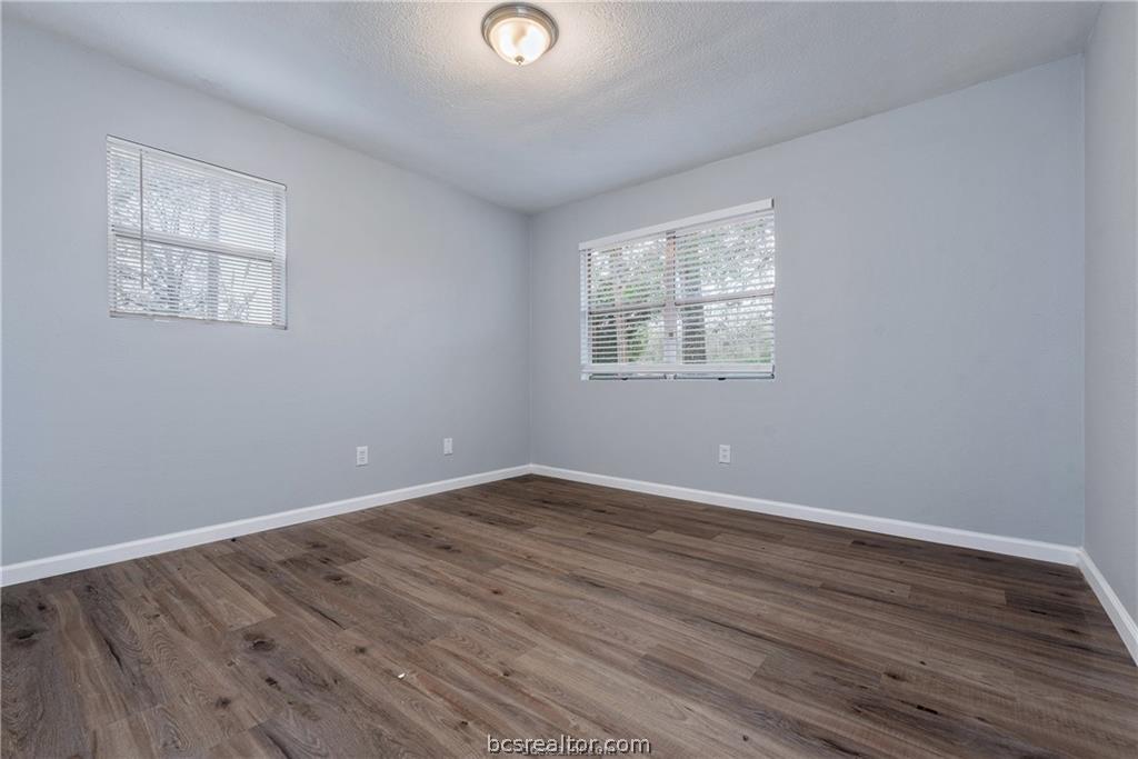 3755 West Villa Maria Road Bryan, TX 77807 - Photo 14 of 26 Bedroom featuring dark wood finished floors and a textured ceiling