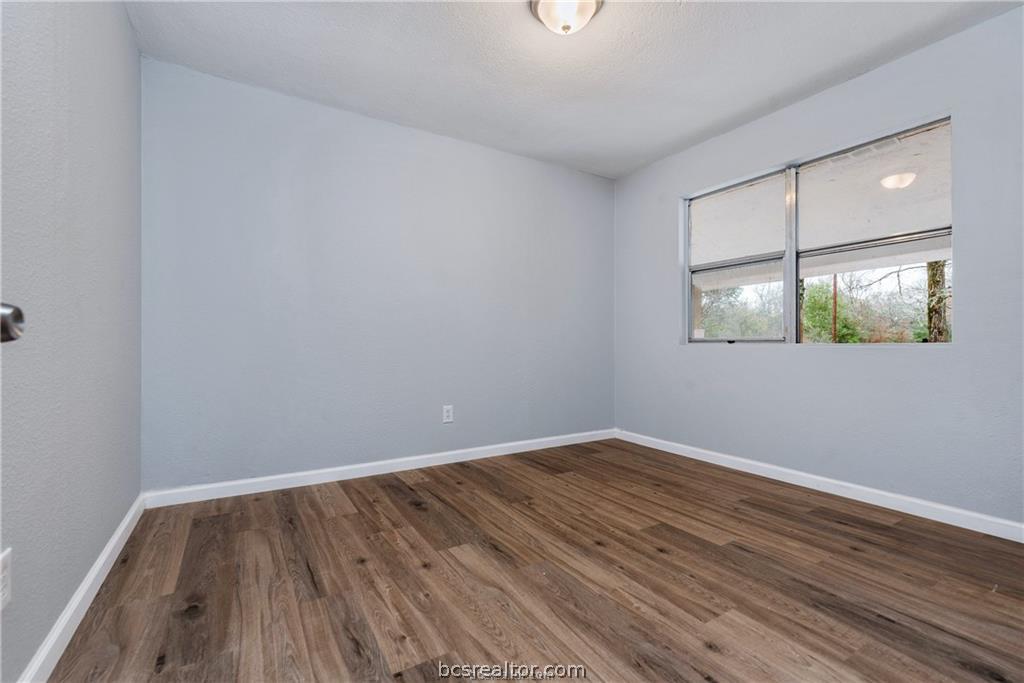 3755 West Villa Maria Road Bryan, TX 77807 - Photo 15 of 26 Bedroom with dark wood-style flooring and baseboards