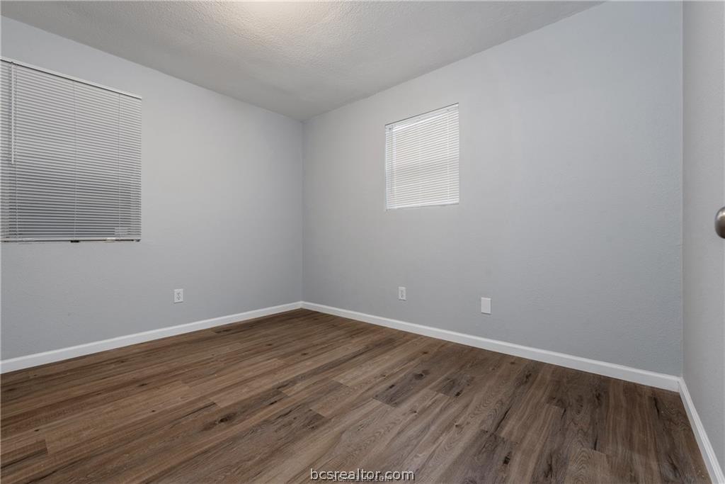 3755 West Villa Maria Road Bryan, TX 77807 - Photo 17 of 26 Bedroom with dark wood-type flooring and a textured ceiling