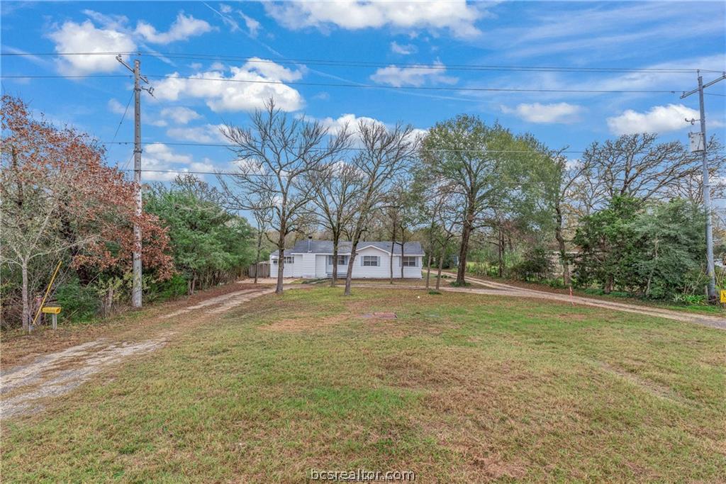 3755 West Villa Maria Road Bryan, TX 77807 - Photo 25 of 26 View of grassy yard featuring driveway and view of wooded area