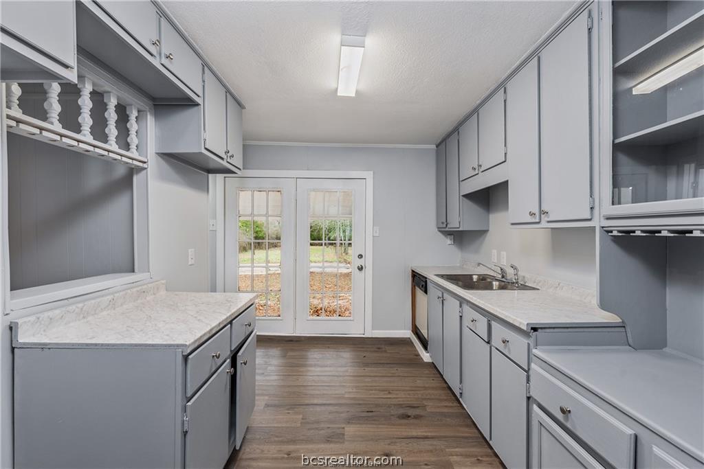 3755 West Villa Maria Road Bryan, TX 77807 - Photo 8 of 26 Kitchen with gray cabinetry, light countertops, dark wood-style floors, a textured ceiling, and glass fronted cabinets