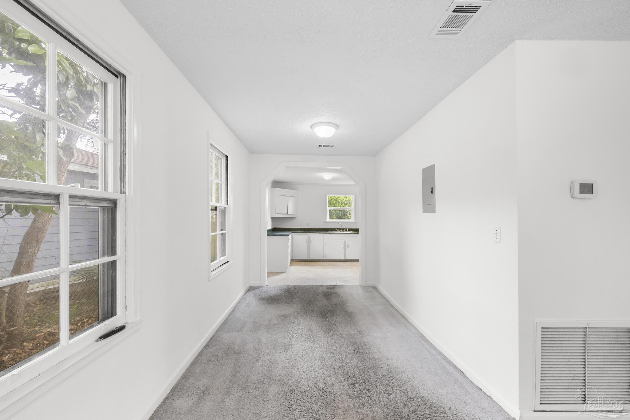 208 Berry Road Pensacola, FL 32507 - Photo 13 of 41 a view of a hallway with wooden floor and a kitchen