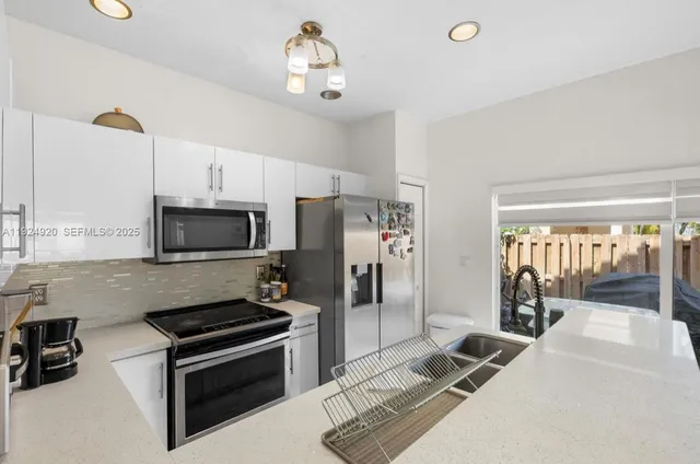 a kitchen with stainless steel appliances a stove a sink and a refrigerator