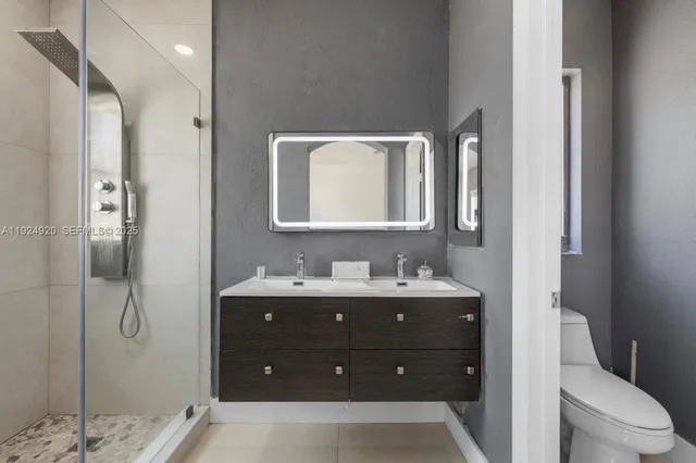 a bathroom with a toilet sink and mirror