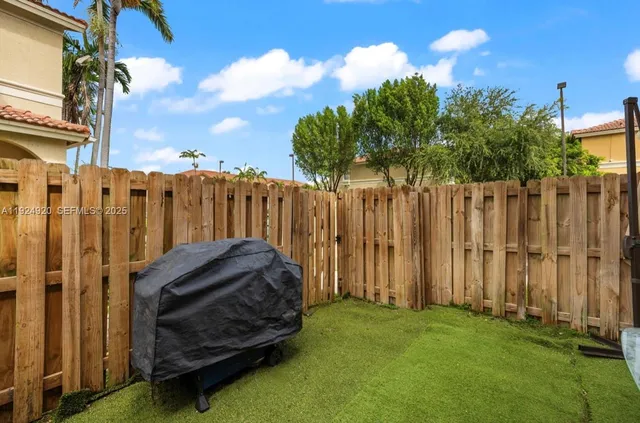 a view of a house with backyard and wooden fence