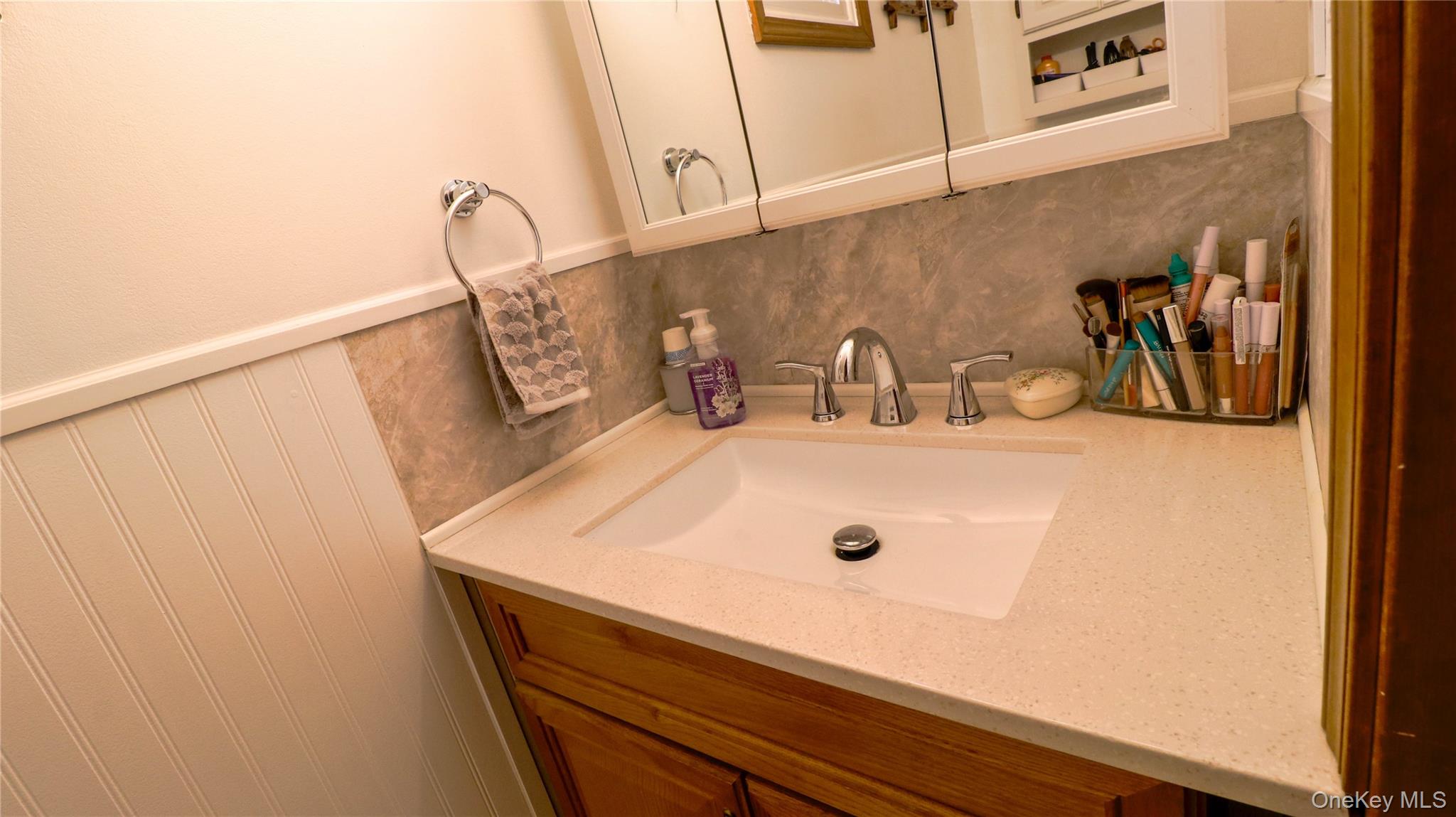 11 Hood Road Roscoe, NY 12776 - Photo 16 of 31 Bathroom vanity featuring a light-colored solid surface countertop with an integrated rectangular sink and chrome faucet
