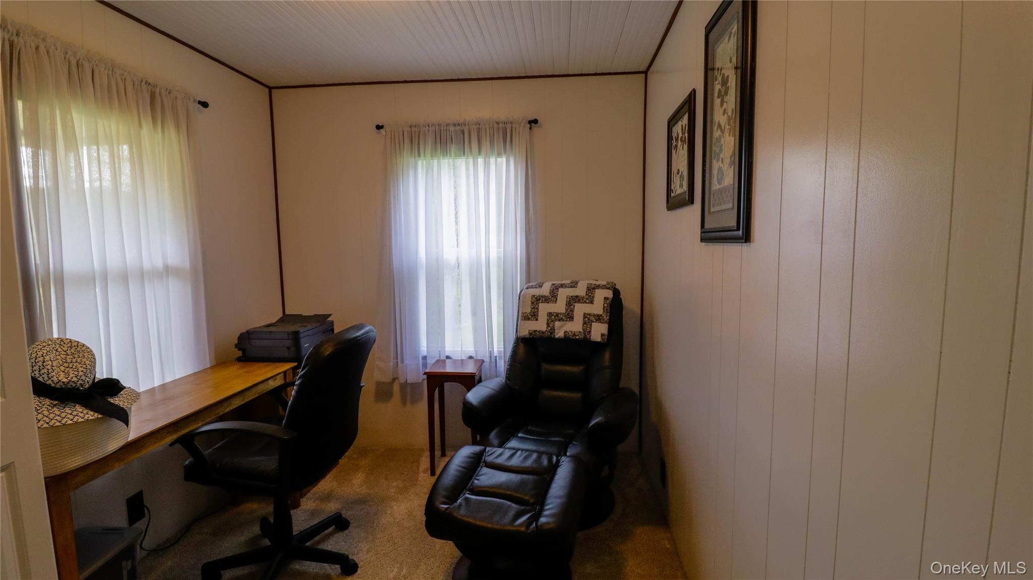 11 Hood Road Roscoe, NY 12776 - Photo 20 of 31 Room featuring two windows with sheer curtains, a built-in wood-finish desk, vertical wall paneling, and a white beadboard ceiling
