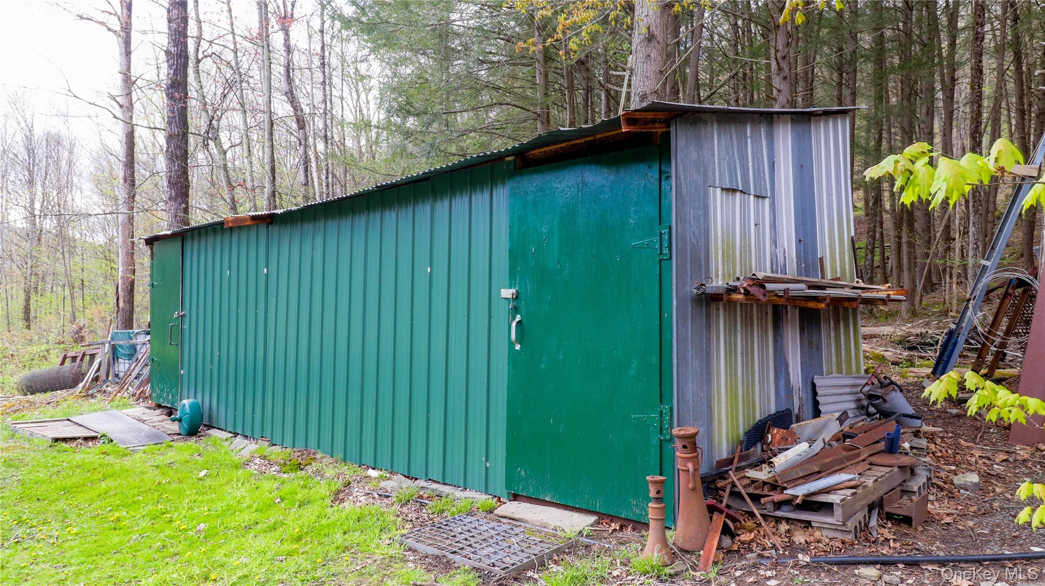 11 Hood Road Roscoe, NY 12776 - Photo 23 of 31 Long metal storage shed with a corrugated green facade and a galvanized steel side panel