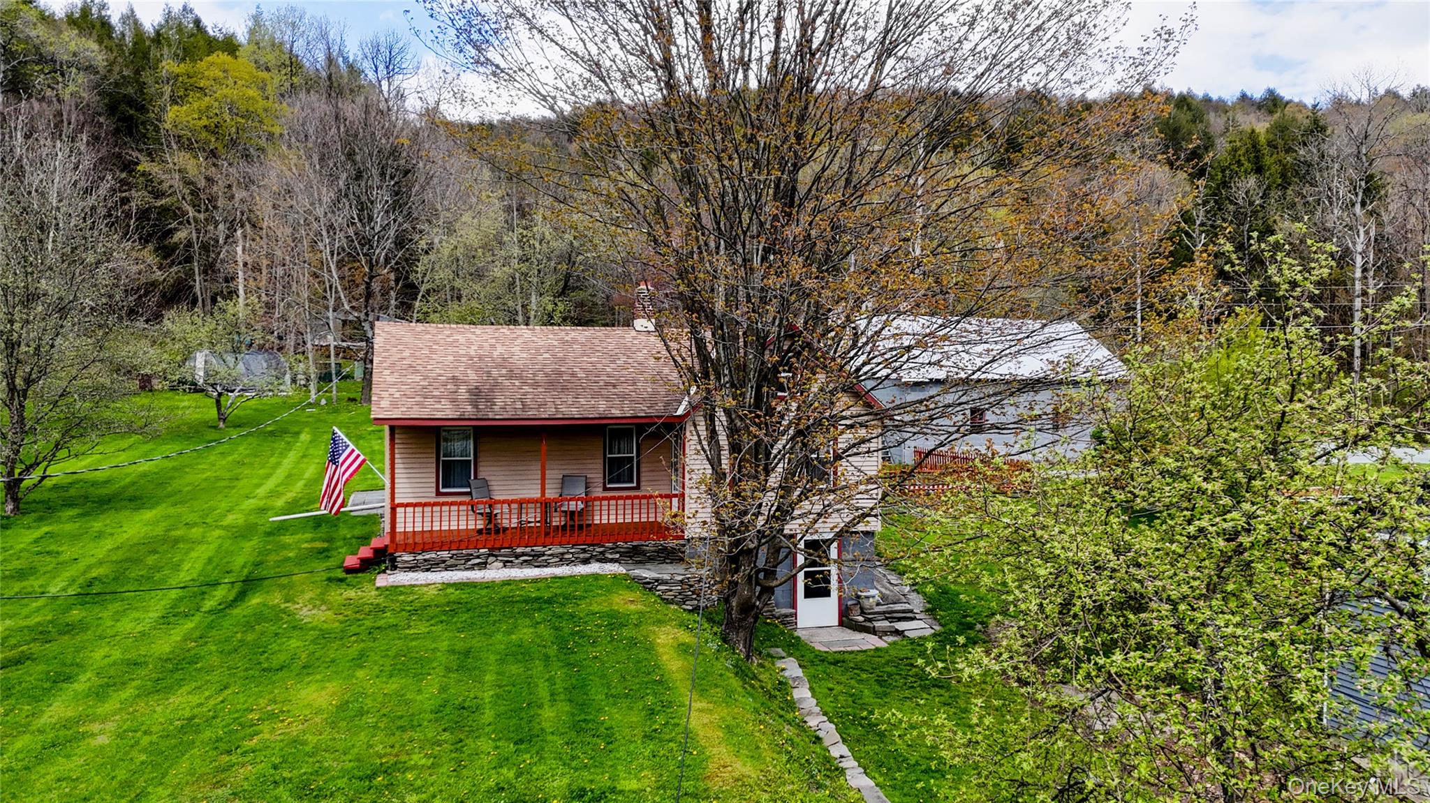 11 Hood Road Roscoe, NY 12776 - Photo 5 of 31 Exterior featuring a red-railed porch, light-colored siding, and a brown shingled roof