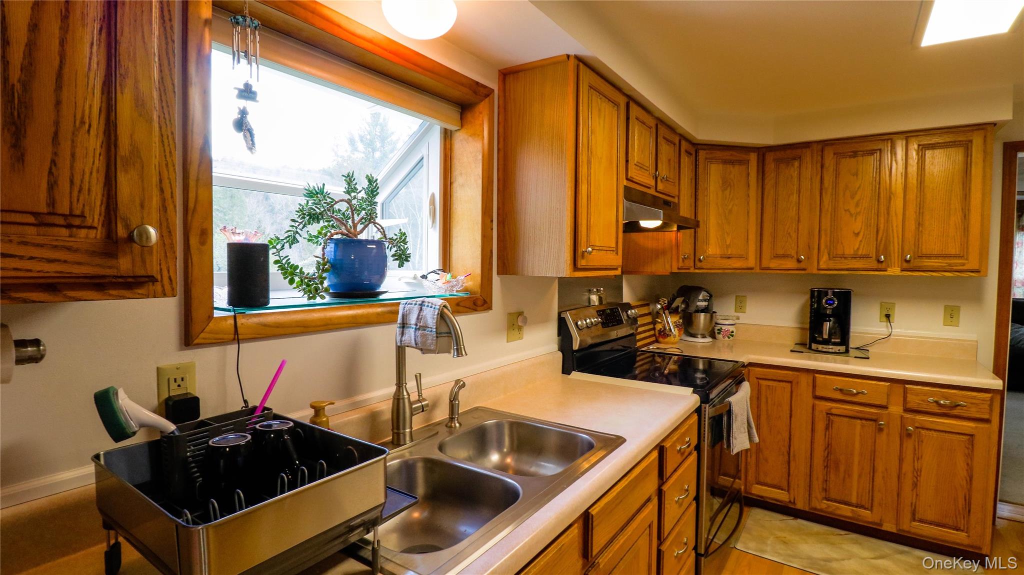 11 Hood Road Roscoe, NY 12776 - Photo 9 of 31 Kitchen featuring wood cabinetry, a double basin stainless steel sink, light-toned countertops, and a black electric range