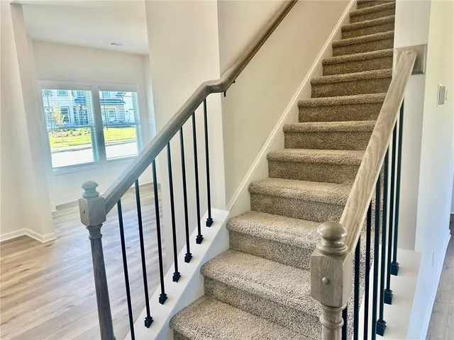 a view of staircase with wooden floor and white walls