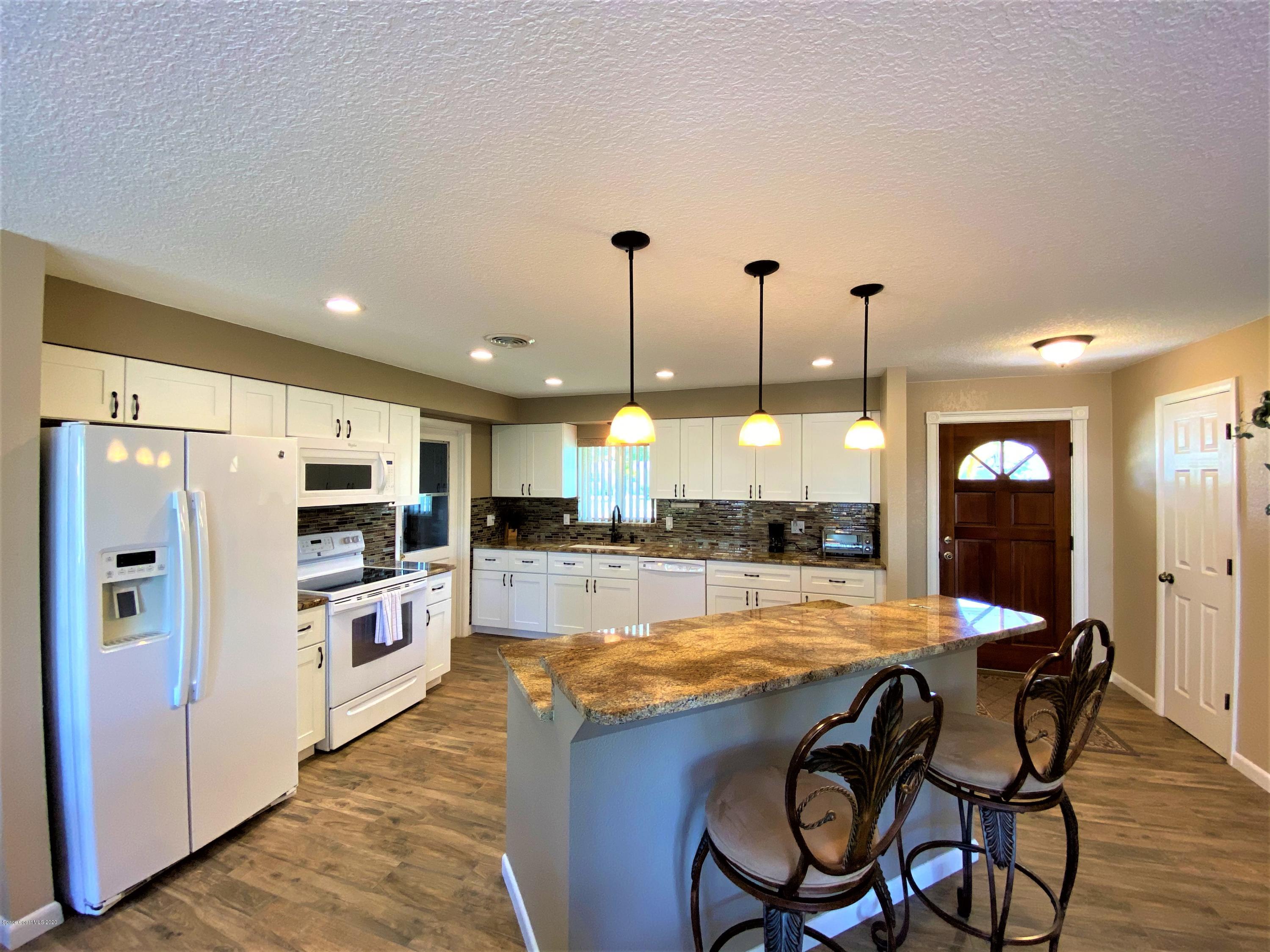 175 Tiki Drive Merritt Island, FL 32953 - Photo 5 of 15 a view of a kitchen with kitchen island dining table and stainless steel appliances