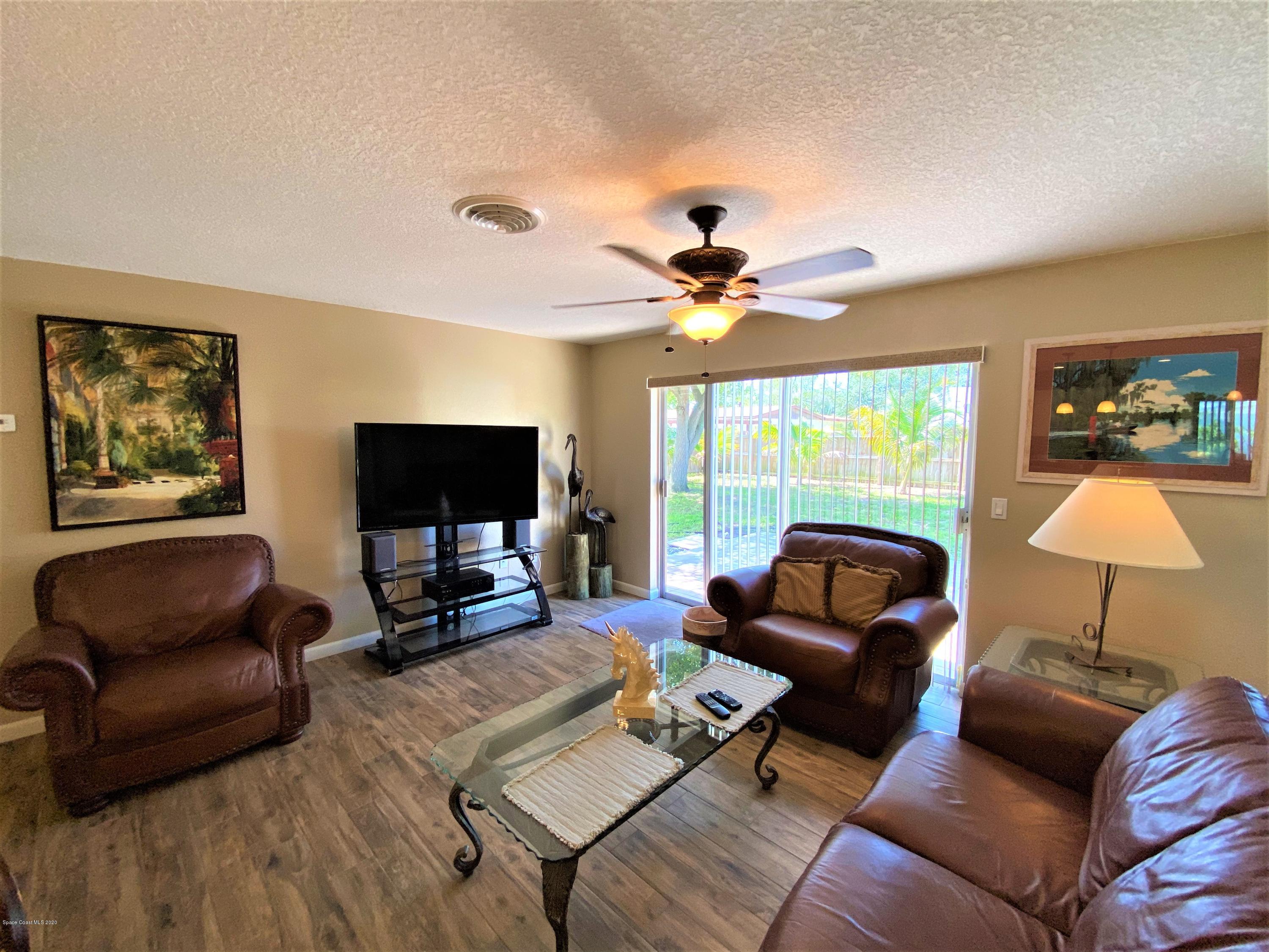 175 Tiki Drive Merritt Island, FL 32953 - Photo 6 of 15 a living room with furniture a flat screen tv and a large window