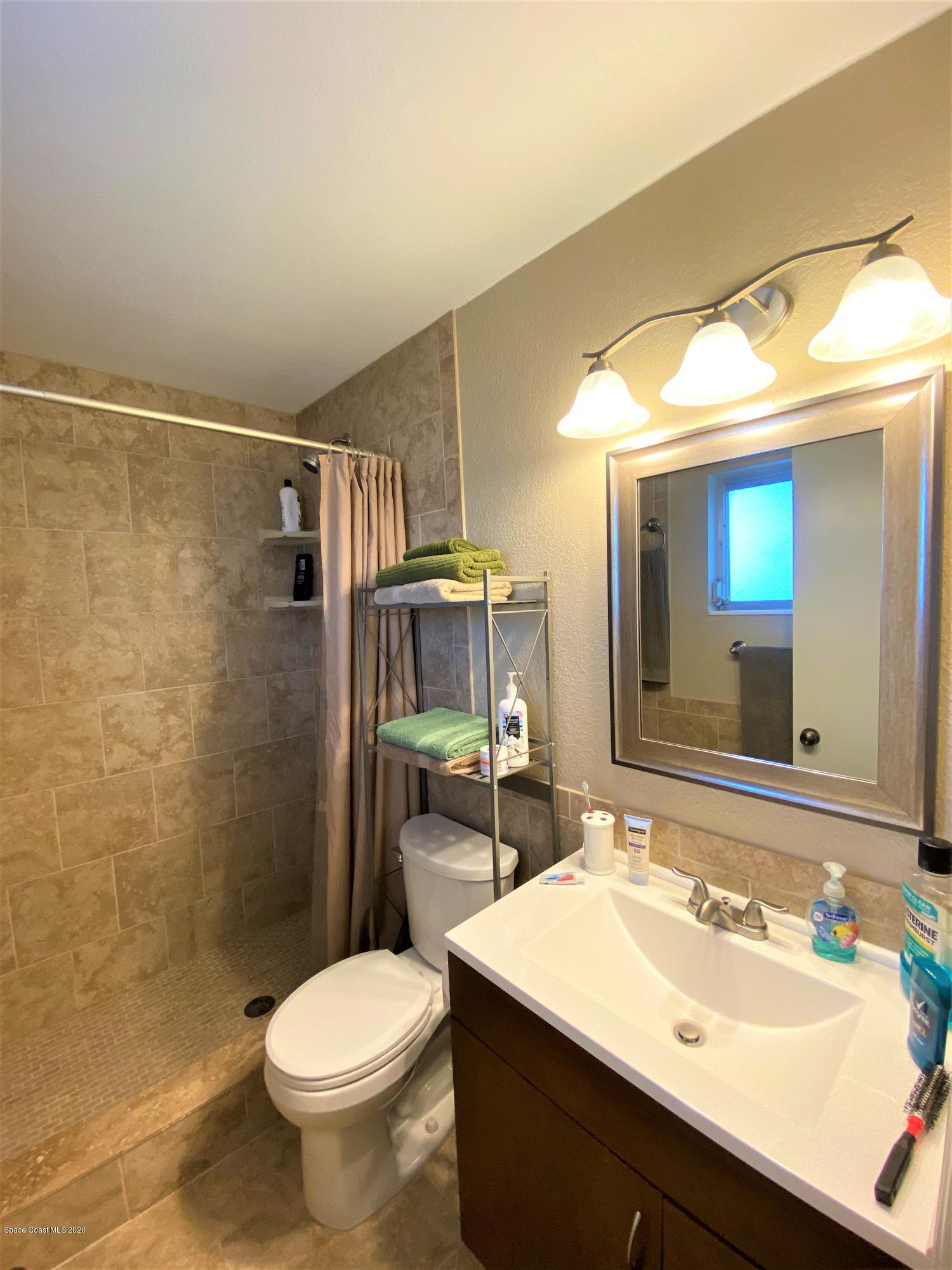 175 Tiki Drive Merritt Island, FL 32953 - Photo 9 of 15 a bathroom with a sink toilet and shower