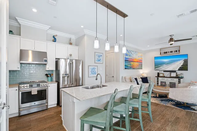 a kitchen with stainless steel appliances kitchen island granite countertop a table chairs microwave and sink