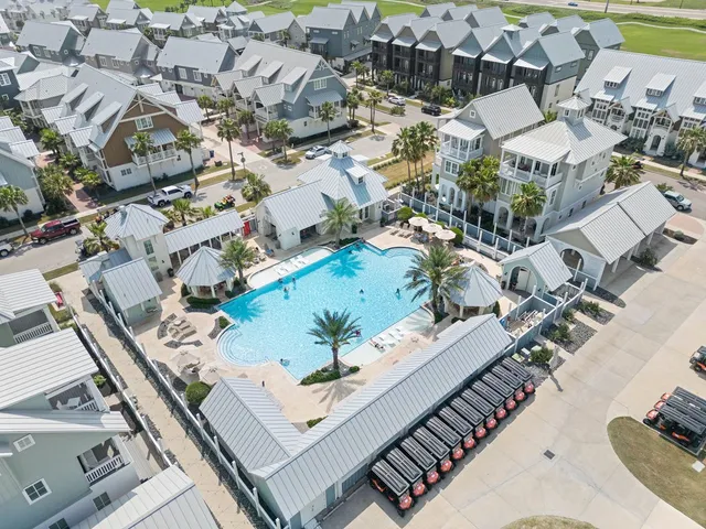 a front view of a house with a garden and lake view