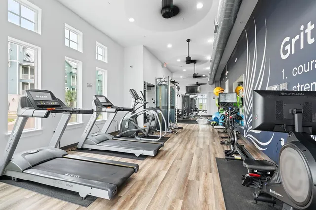 a living room with furniture gym equipment and a large window