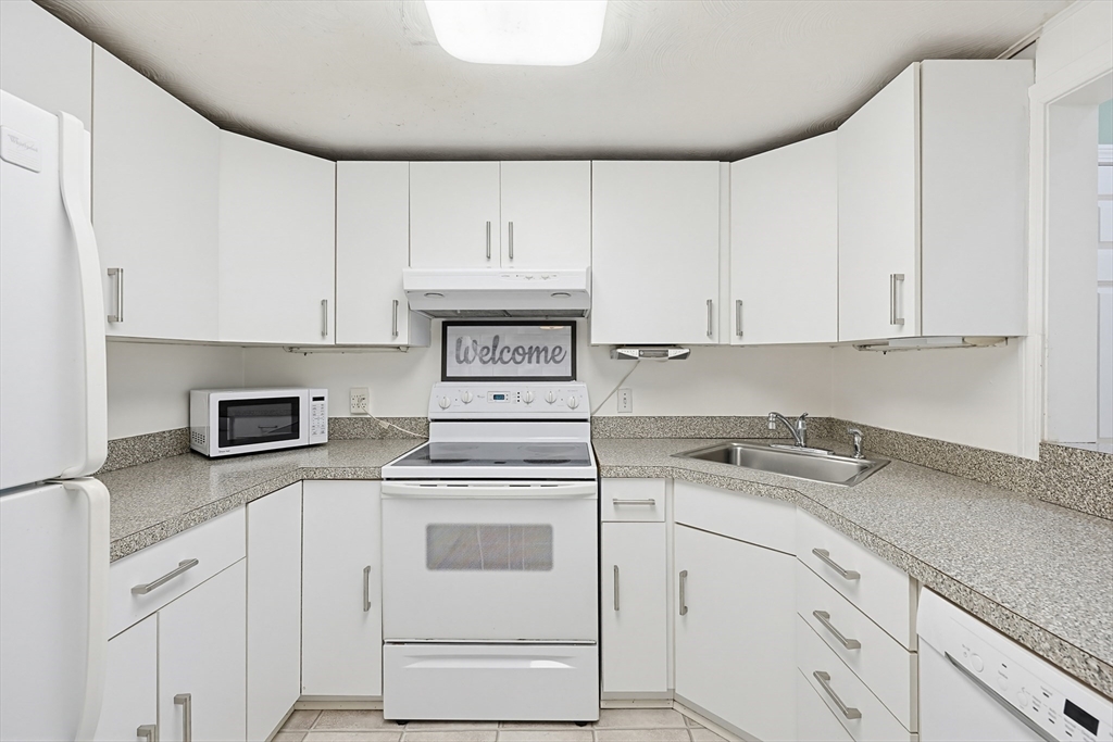 118 Spruce Road Norwood, MA 02062 - Photo 27 of 39 a kitchen with granite countertop white cabinets and white appliances