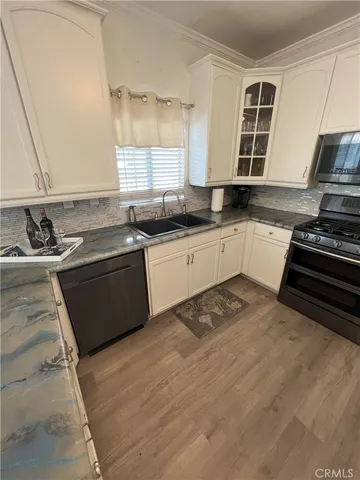 a kitchen with stainless steel appliances granite countertop a sink stove and cabinets