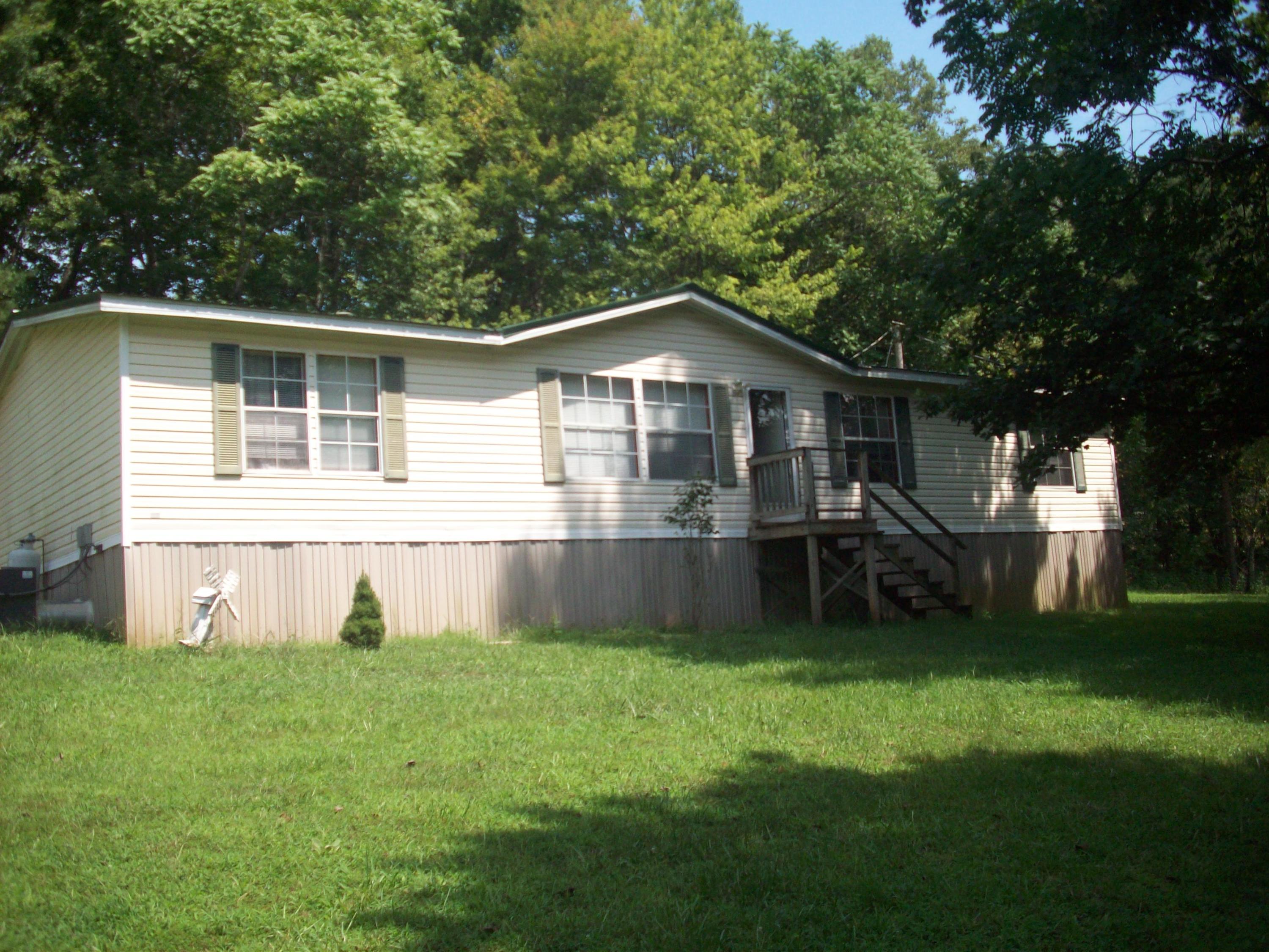 205 Board Mountain Road Goodview, VA 24095 - Photo 1 of 17 a front view of a house with a garden and yard