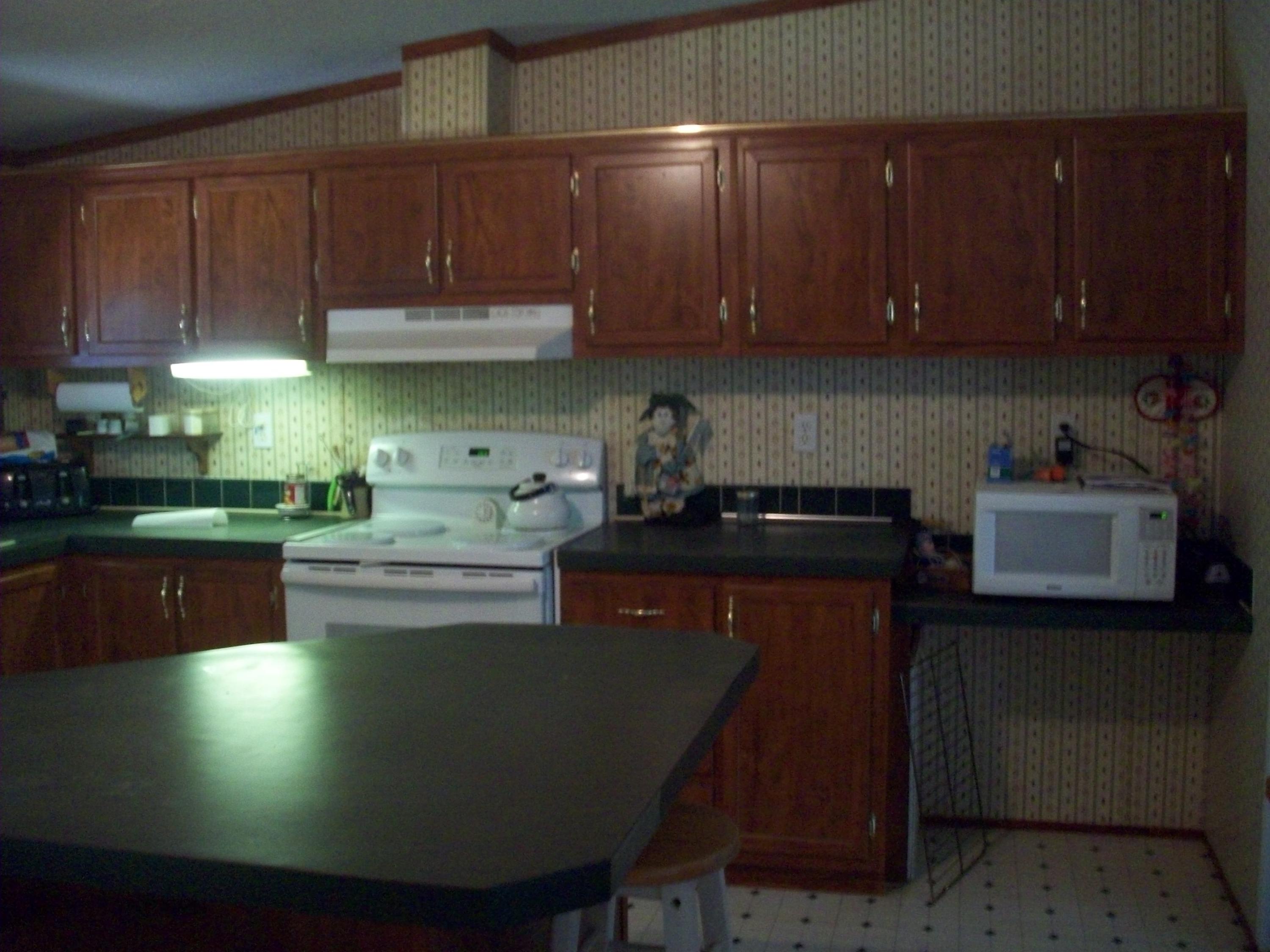 205 Board Mountain Road Goodview, VA 24095 - Photo 3 of 17 a kitchen with a table chairs stove and cabinets