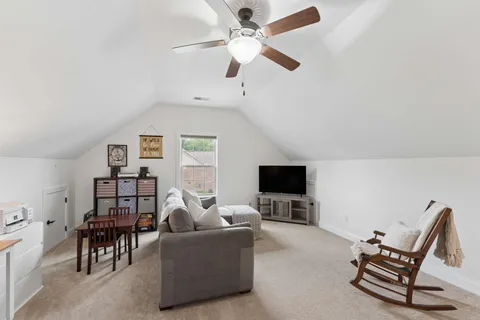 a living room with furniture a ceiling fan and a fireplace
