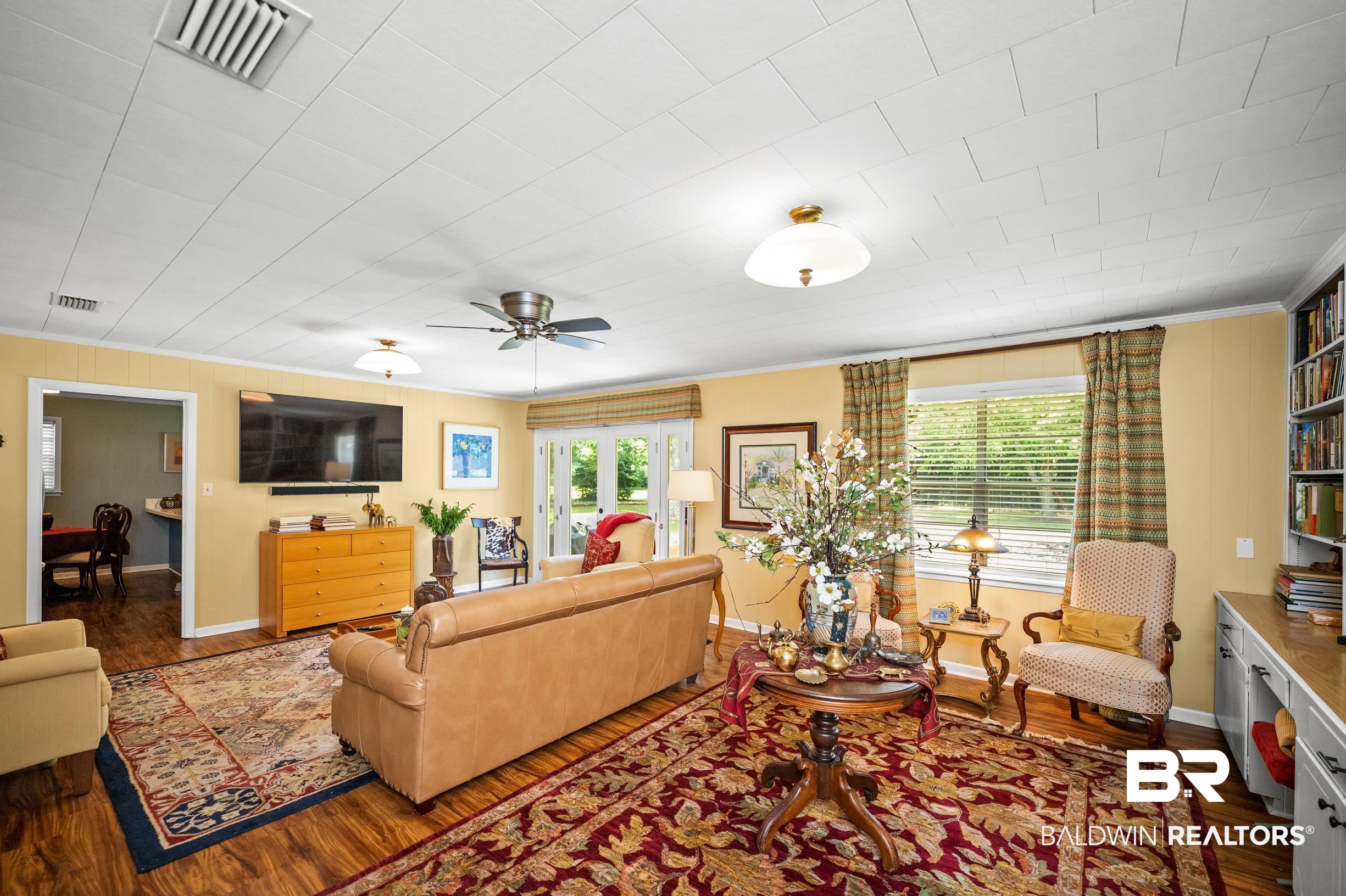 56 Old Bratt Road Atmore, AL 36502 - Photo 9 of 37 Living room with crown molding, wood finished floors, baseboards, and ceiling fan