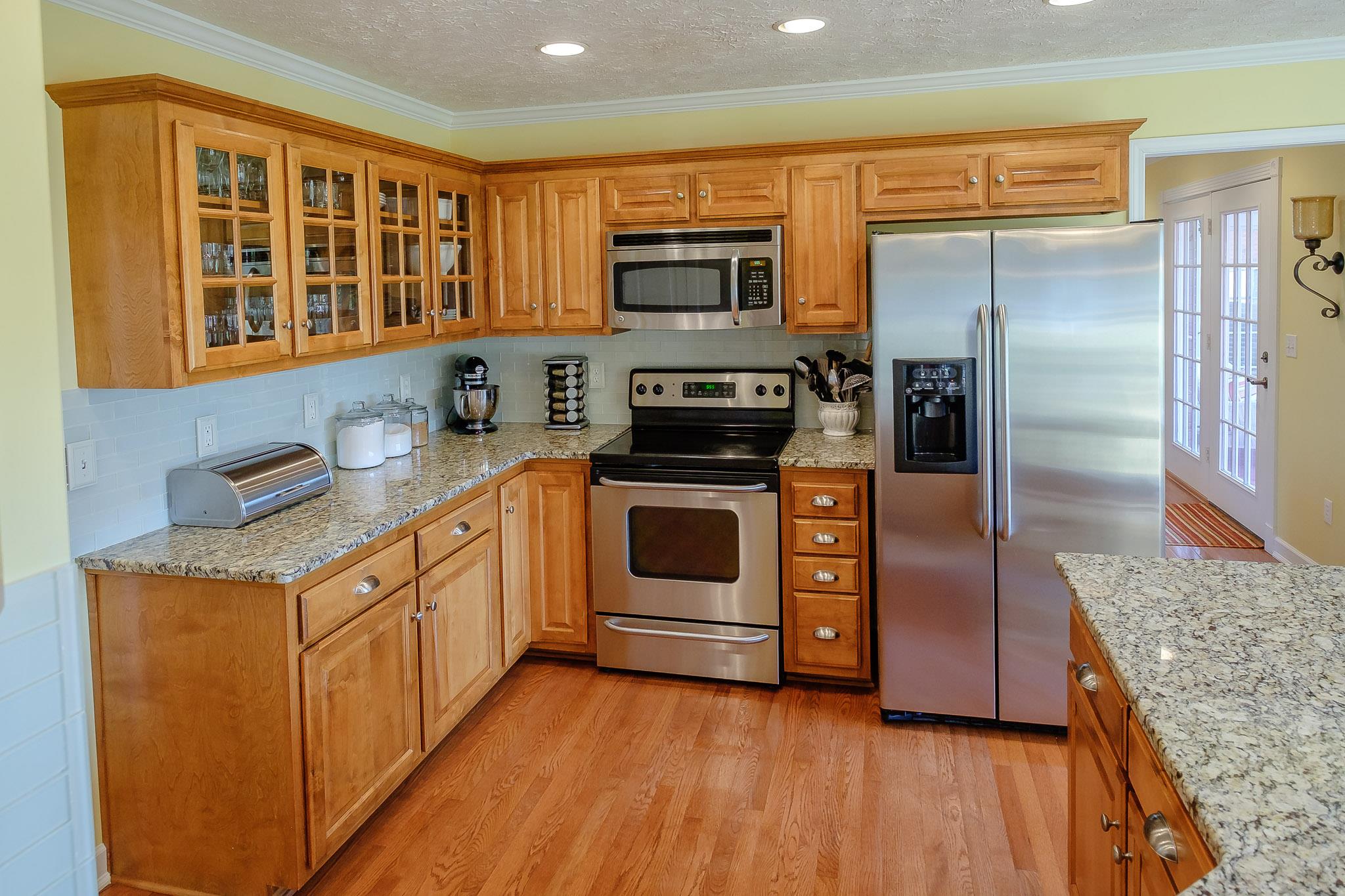329 Urban Farms Road Manchester, TN 37355 - Photo 11 of 29 a kitchen with stainless steel appliances granite countertop a stove a microwave and a refrigerator