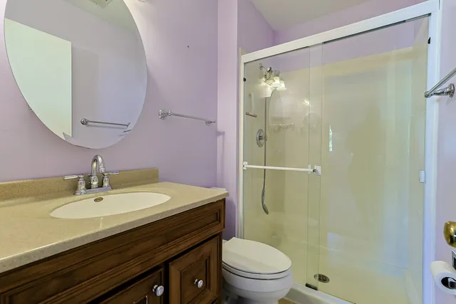 a bathroom with a granite countertop sink toilet and shower