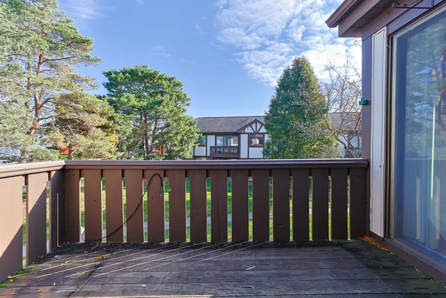 a view of balcony with wooden floor and fence