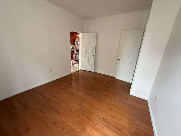 an empty room with wooden floor and closet