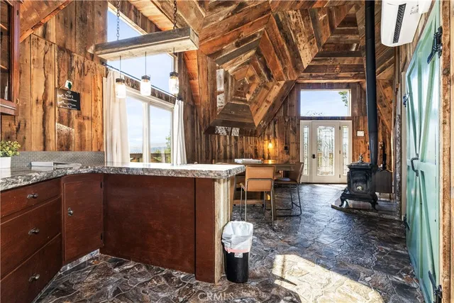 a living room with couches a large dining table and a fireplace with wooden floor