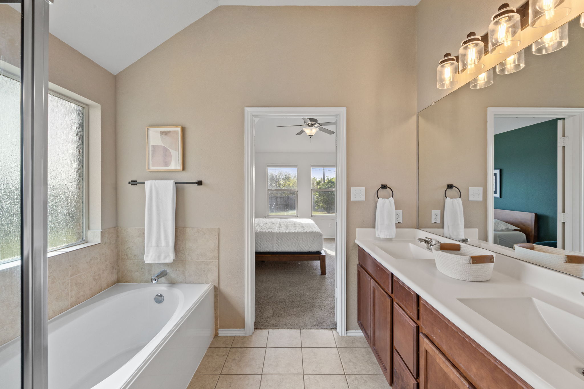 482 Travertine Trail Buda, TX 78610 - Photo 25 of 40 a spacious en suite bathroom with a double vanity sink a large mirror and a bathtub