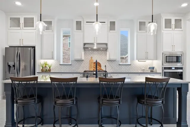 a kitchen with granite countertop a sink cabinets and refrigerator