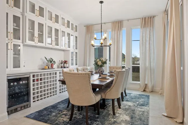 a dining room with furniture a chandelier and kitchen view