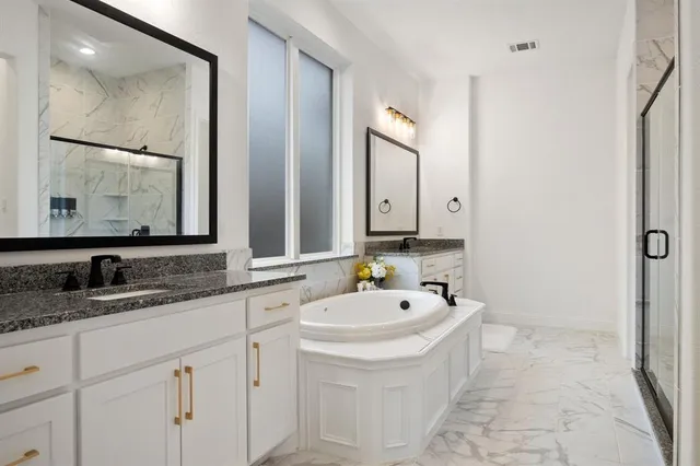 a bathroom with a tub sink and mirror