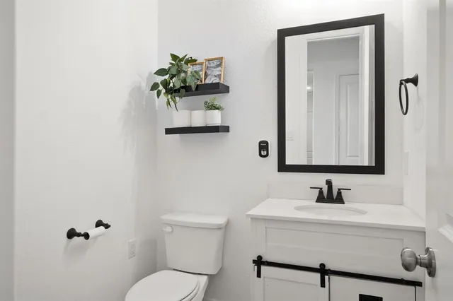 a bathroom with a toilet sink and mirror
