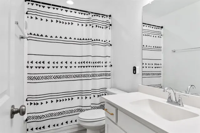 a bathroom with a toilet a sink and a mirror