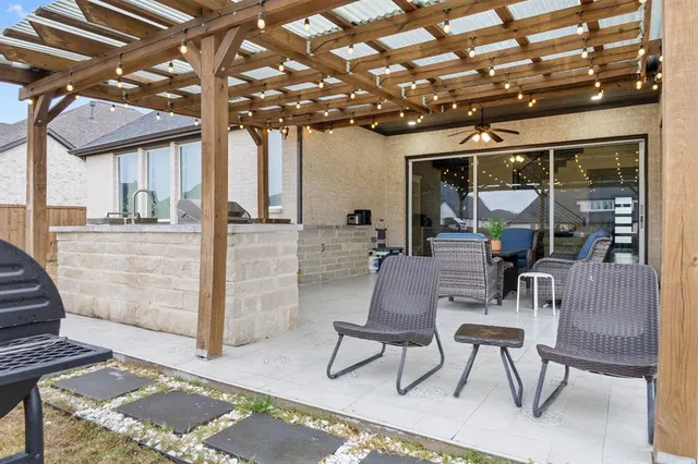 a view of a patio with table and chairs with wooden floor and fence