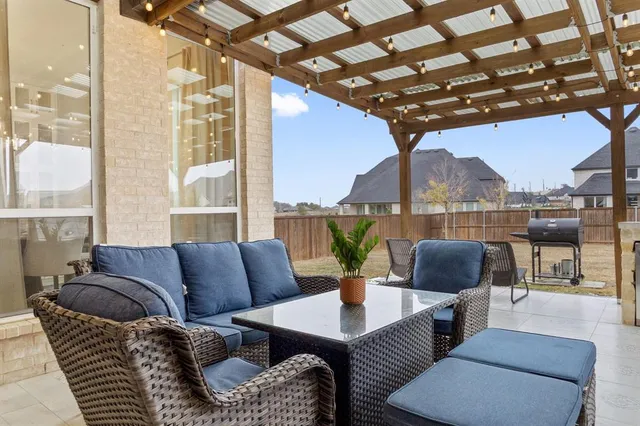 a outdoor living room with furniture and a floor to ceiling window