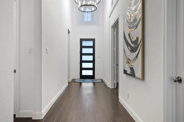 a view of a hallway with wooden floor and stairs