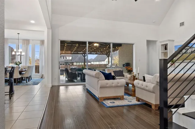 a living room with furniture large window and wooden floor