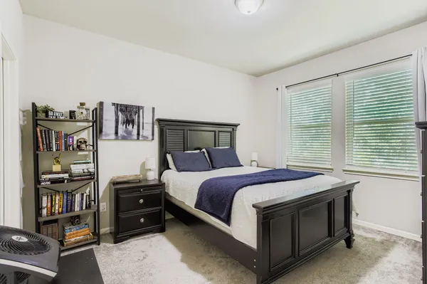 a bed sitting in a bedroom next to a window