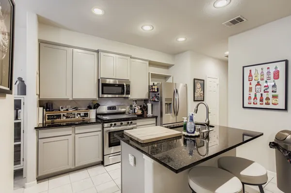 a kitchen with stainless steel appliances granite countertop a sink a stove and a refrigerator