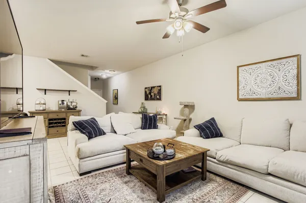 a living room with furniture a ceiling fan and a rug
