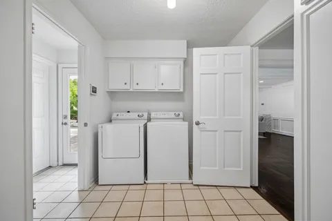 a utility room with cabinets washer and dryer