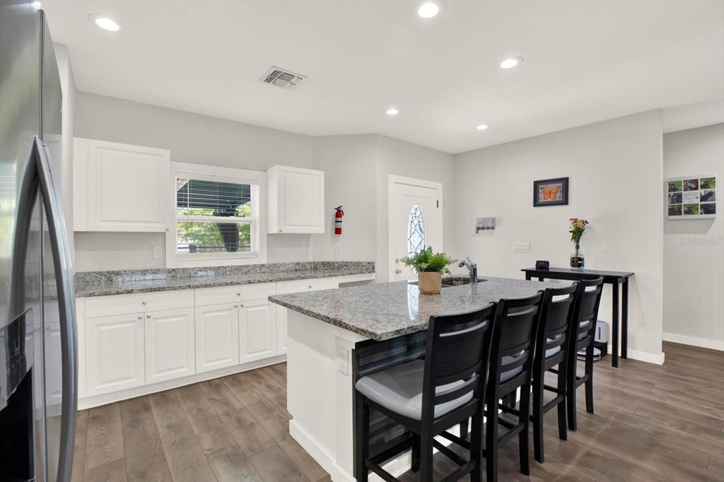 3023 Muir Street Holiday, FL 34691 - Photo 7 of 25 a kitchen with granite countertop stainless steel appliances a sink table and chairs