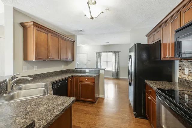a kitchen with granite countertop stainless steel appliances and wooden cabinets